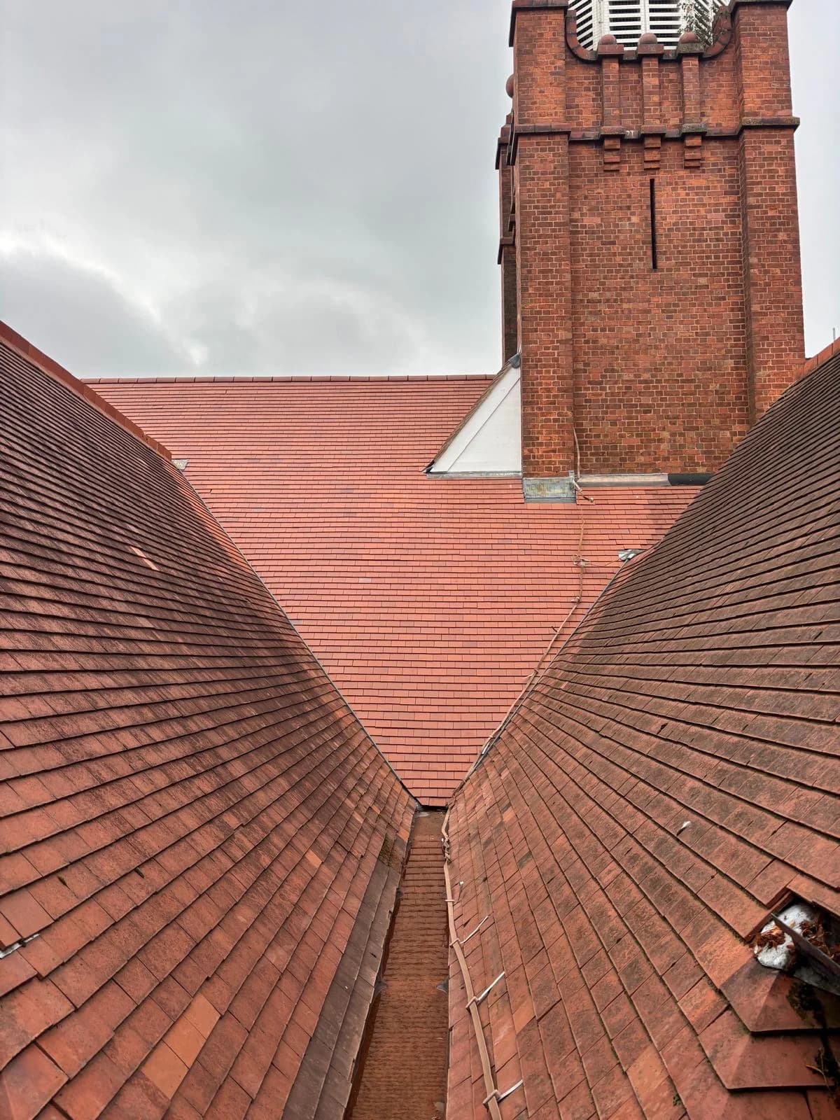 Clay tile pitched roof with brick chimney and lead valley in Burton-on-Trent