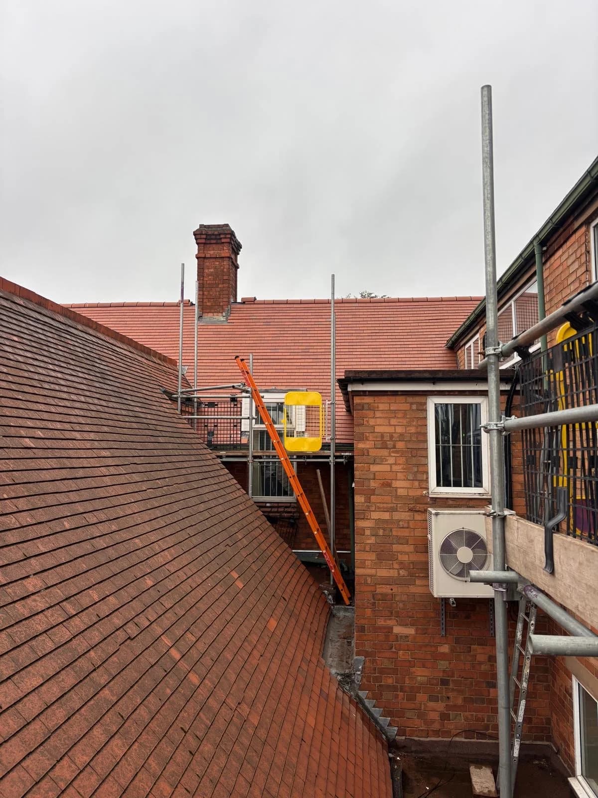 Rooftops, chimneys and scaffolding across a terraced street