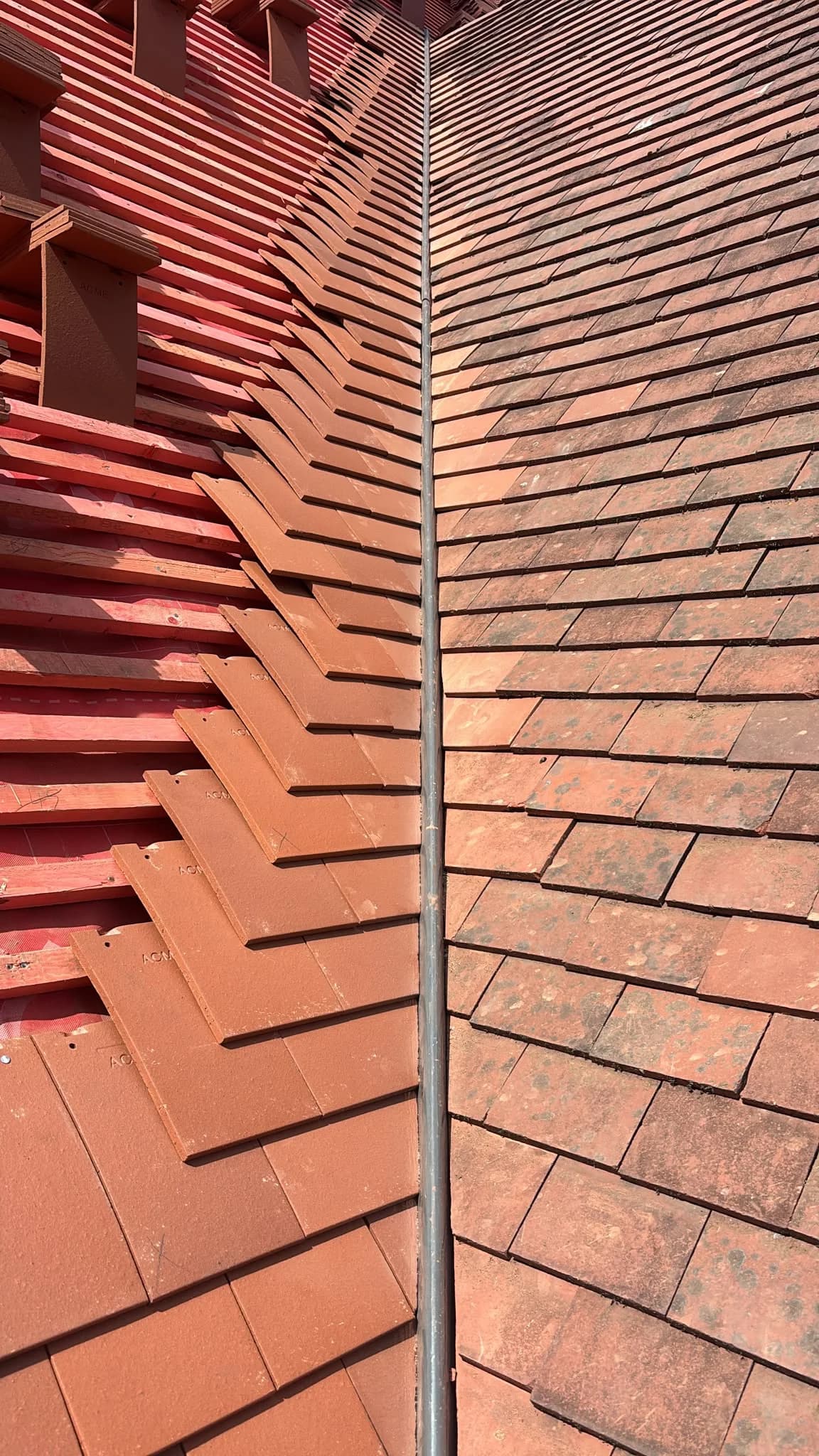 Close-up of red clay ridge tiles on a pitched roof at dusk