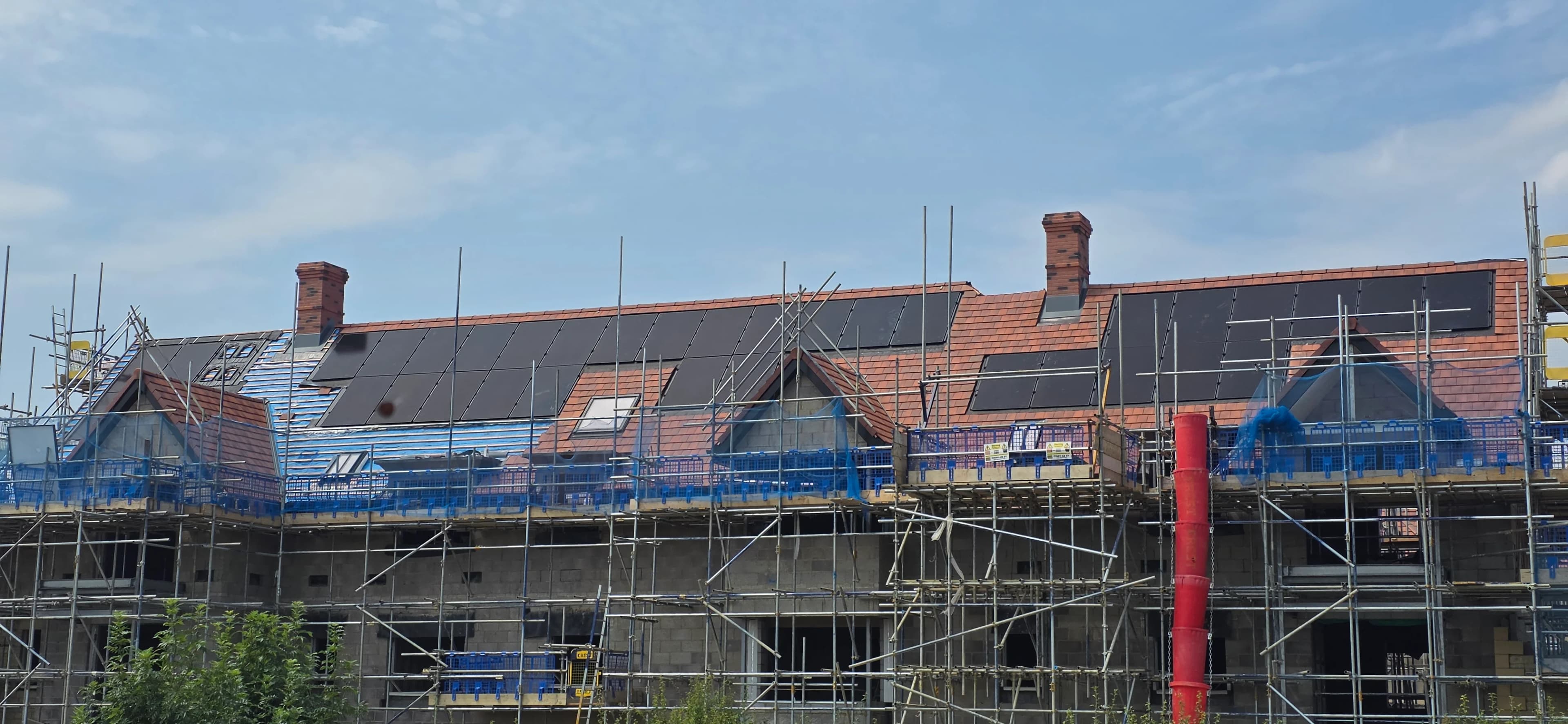 Development of houses with tiled roofs and scaffolding